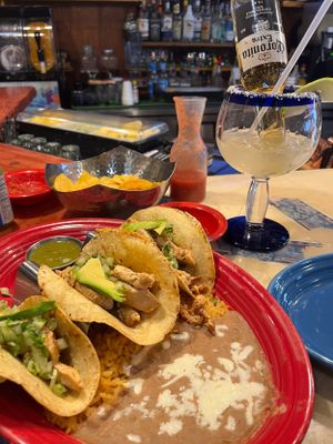 Mexican restaurant table with tacos served on colorful plates.