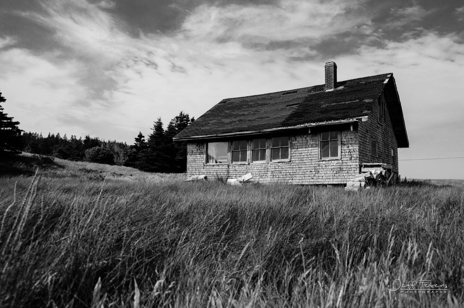 Black and White of an old abandoned home in an grassy field.
