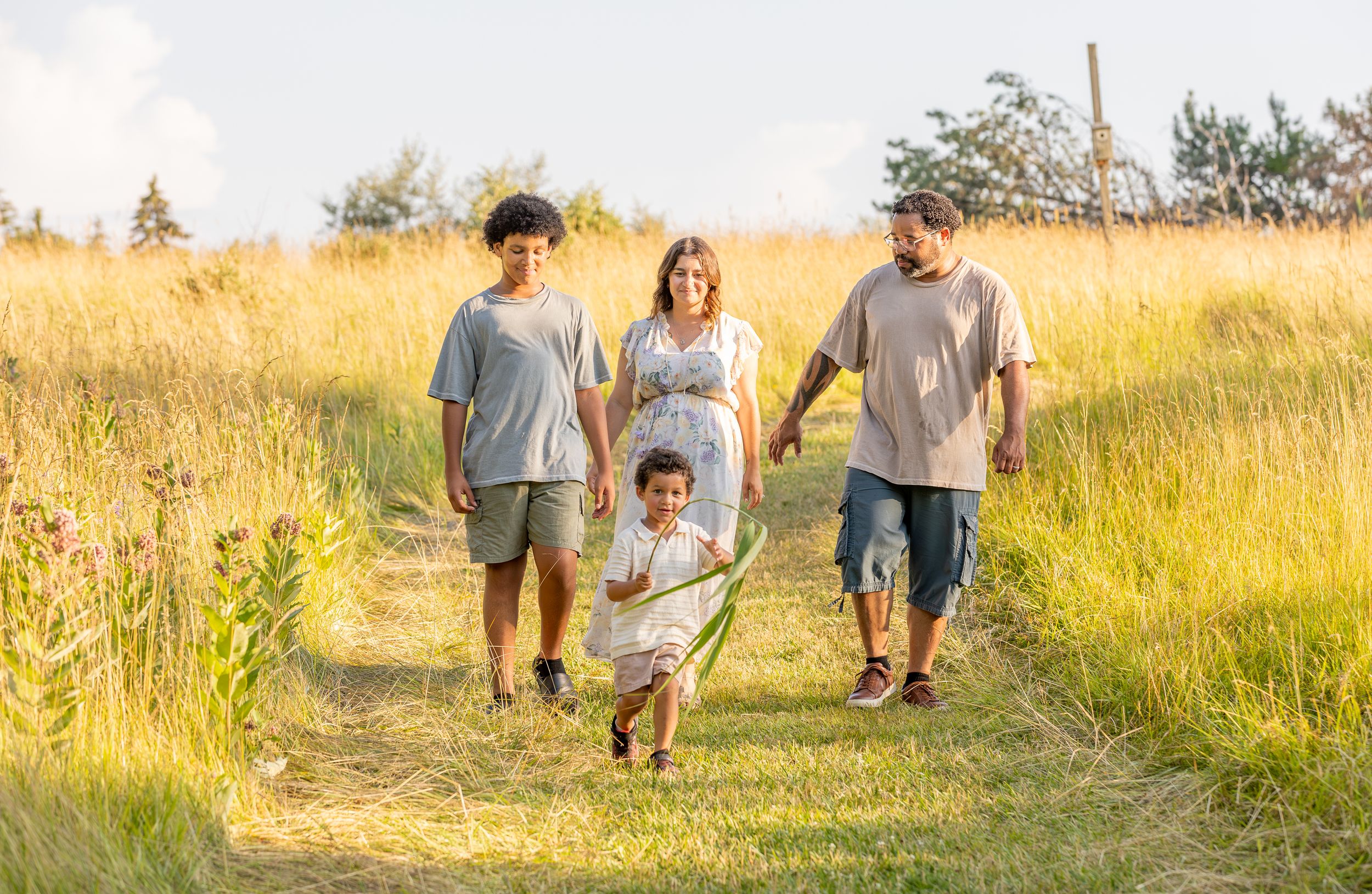 A group walks together through a sunlit meadow during golden hour.