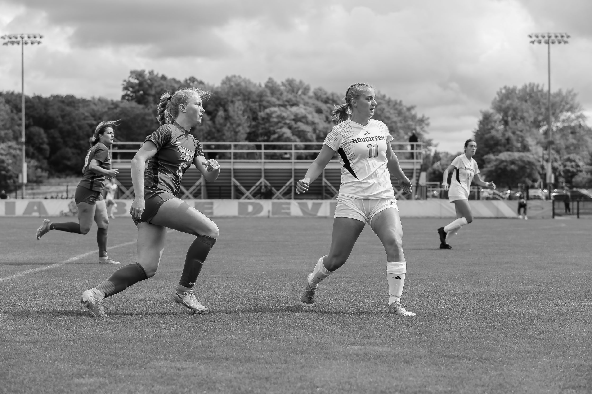 Black and white soccer match sequence showing players competing for ball control on field.