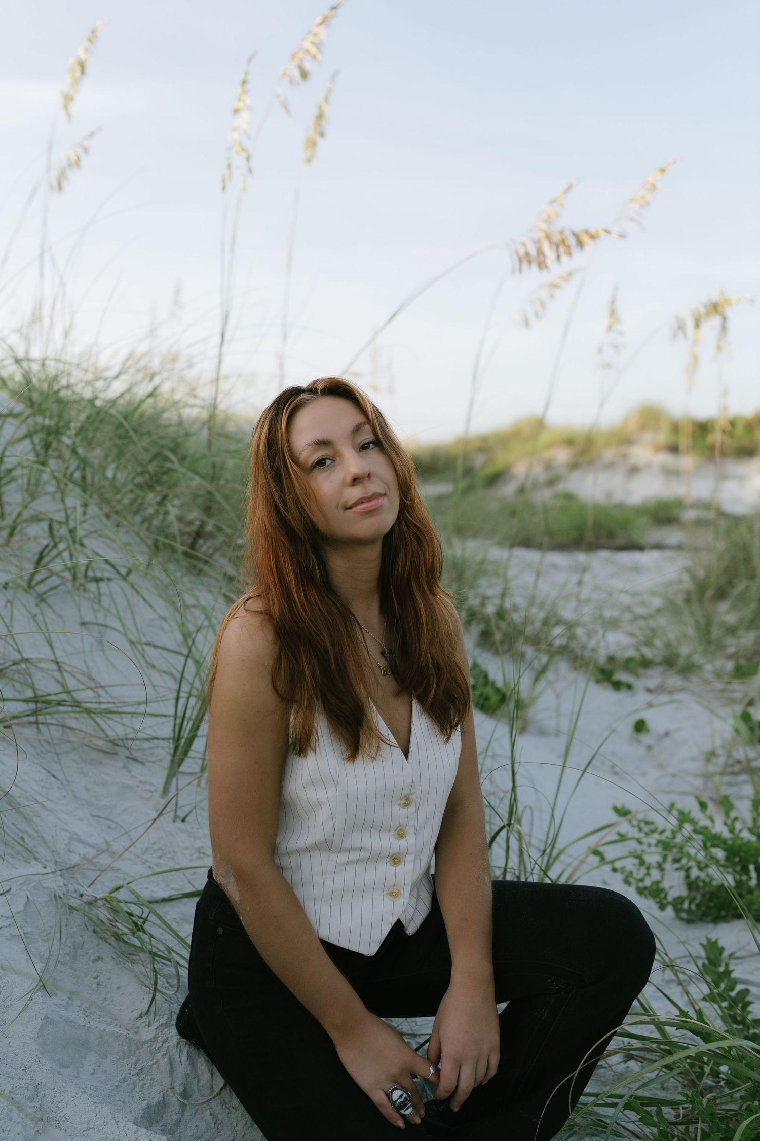 Portrait in coastal dunes with sea oats swaying in the breeze.