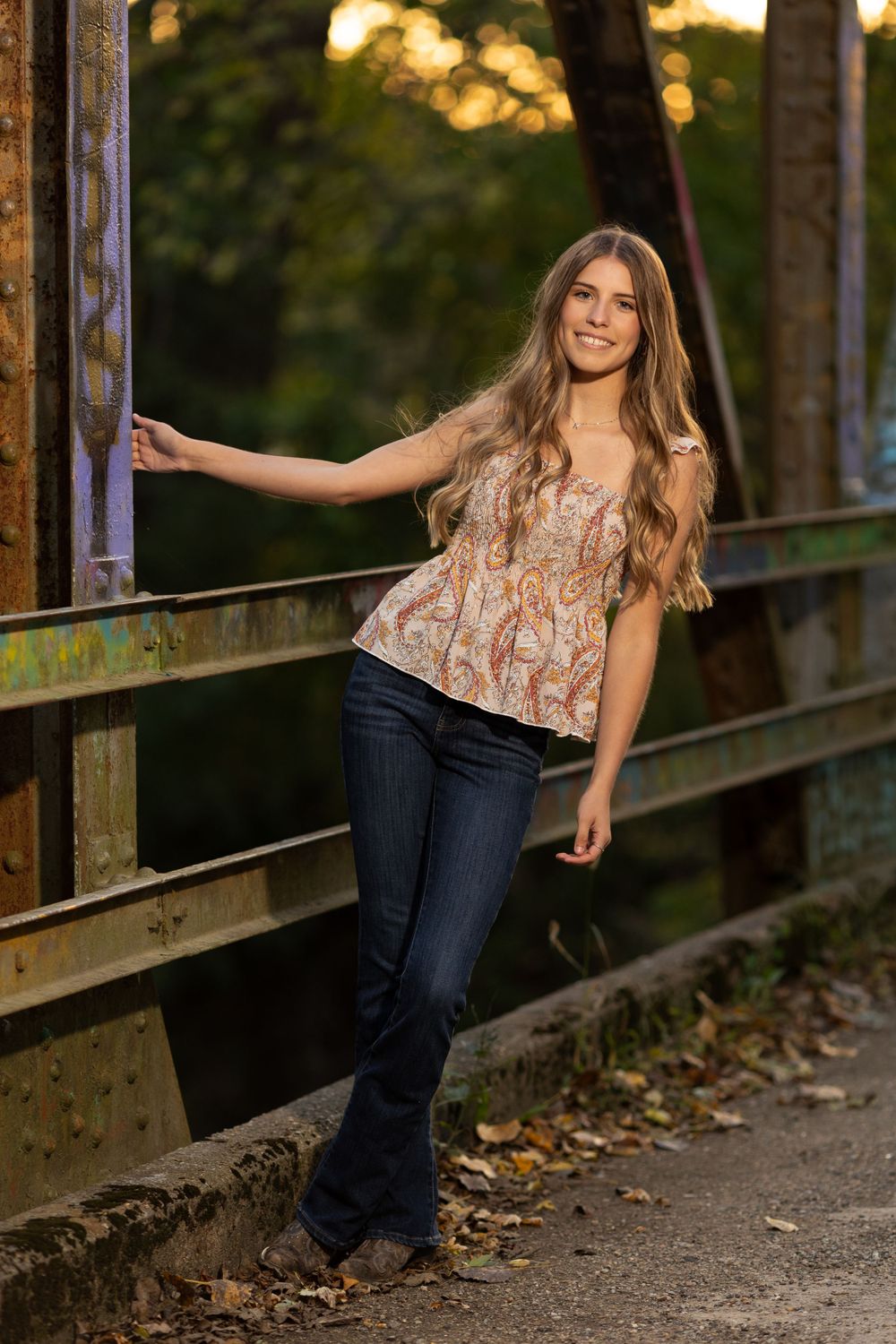 Young lady posing on a metal bridge.