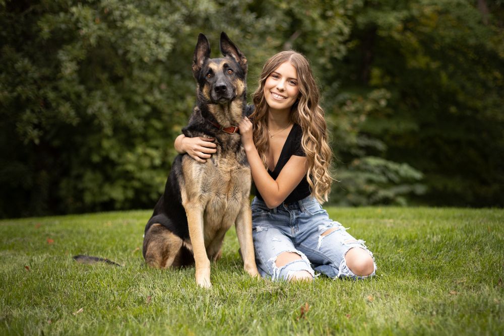 High School girl poses with her dog during her senior portrait session.