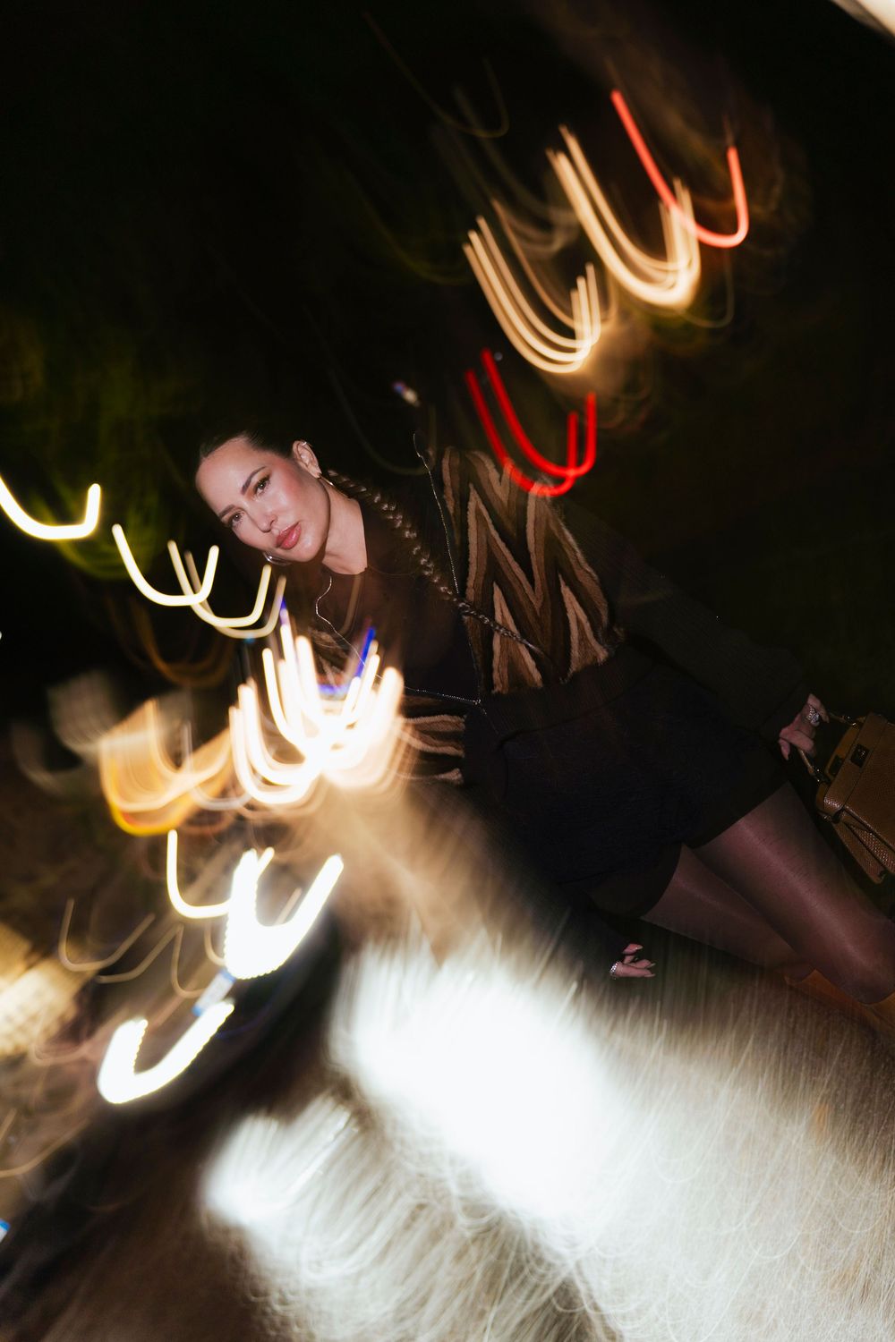Long exposure photograph showing swirling light trails and motion blur effects against a dark background.