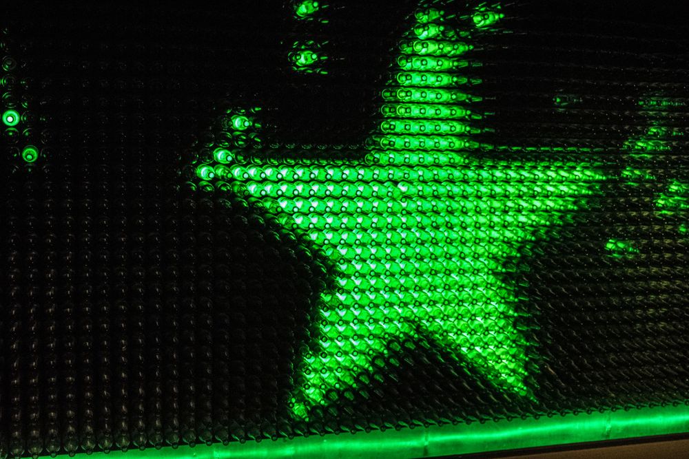 Illuminated green star shape made of LED lights against a dark background.