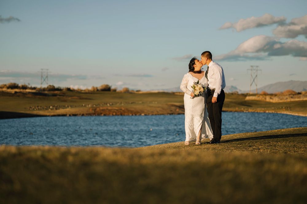 Romantic sunset moment between couple by waterside.