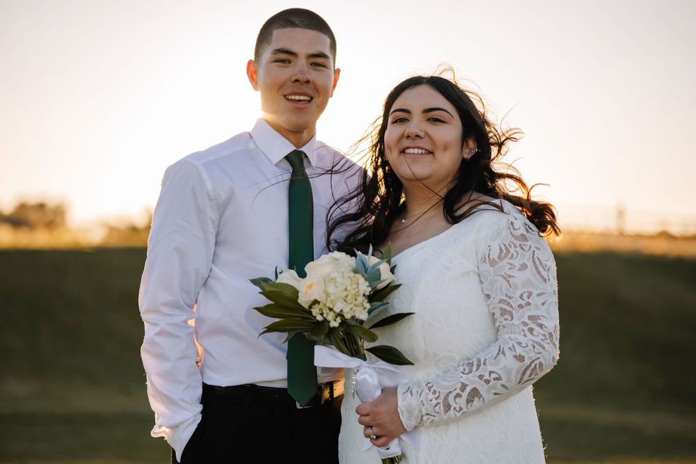 Newlyweds share a joyful moment together outdoors during sunset golden hour.