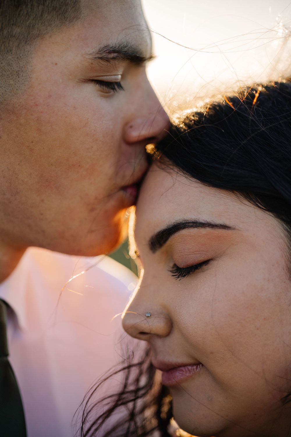 Intimate sunset moment between newlyweds captured in warm golden light.