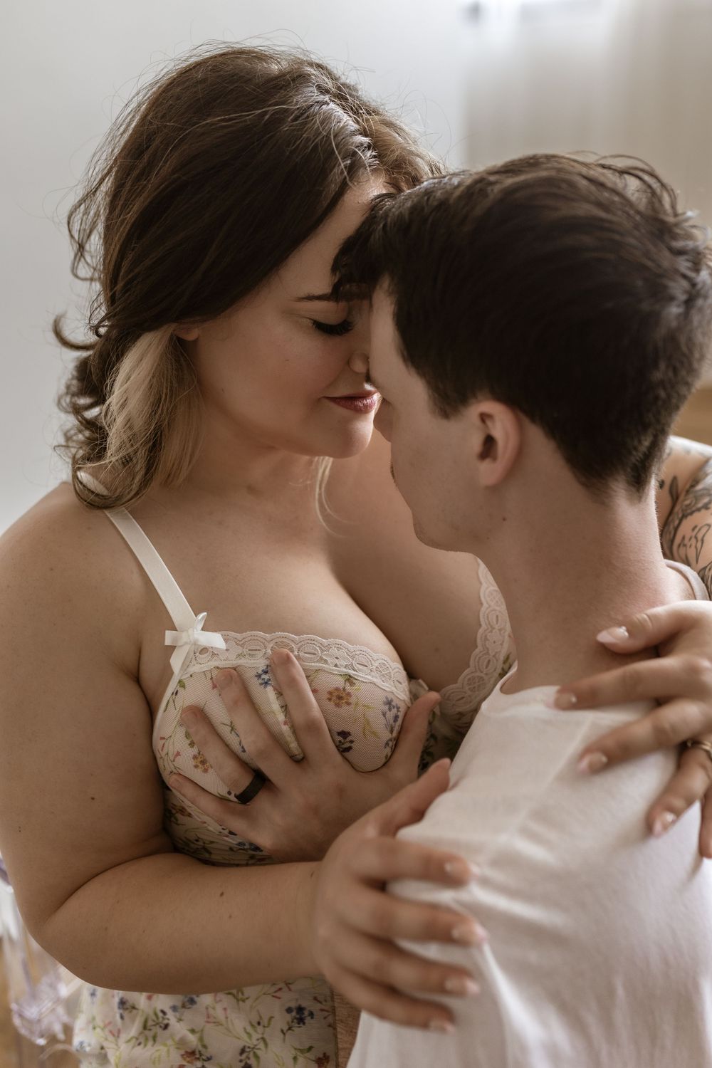 Intimate couple portrait in soft natural light wearing white.