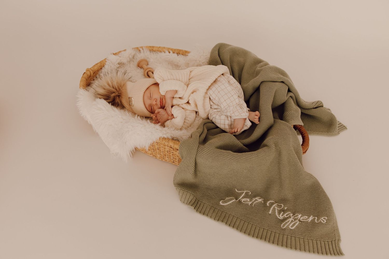 Newborn baby sleeping peacefully on a soft blanket, captured in a cozy indoor photoshoot.