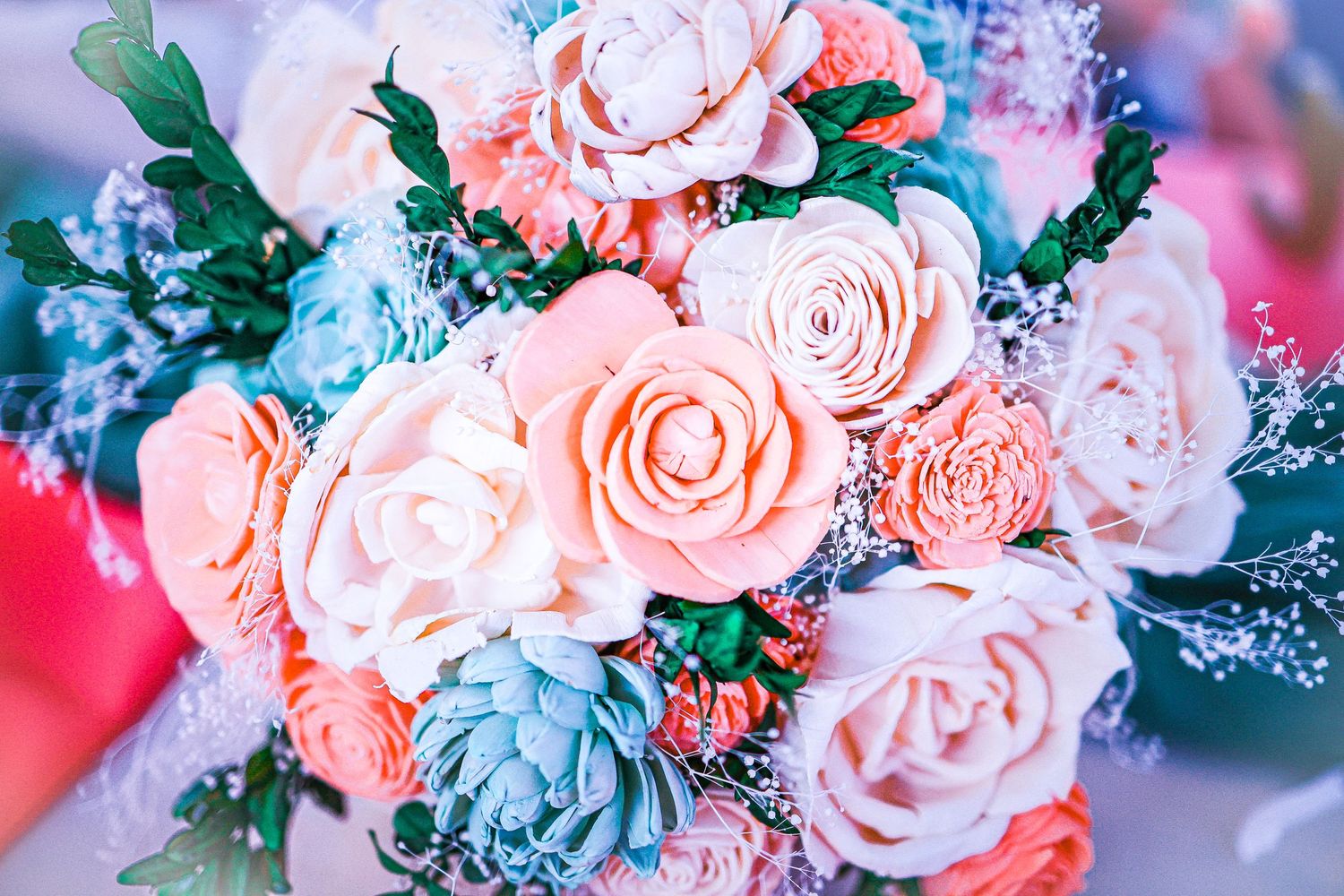 Romantic wedding bouquet featuring pink and blue roses with green foliage.