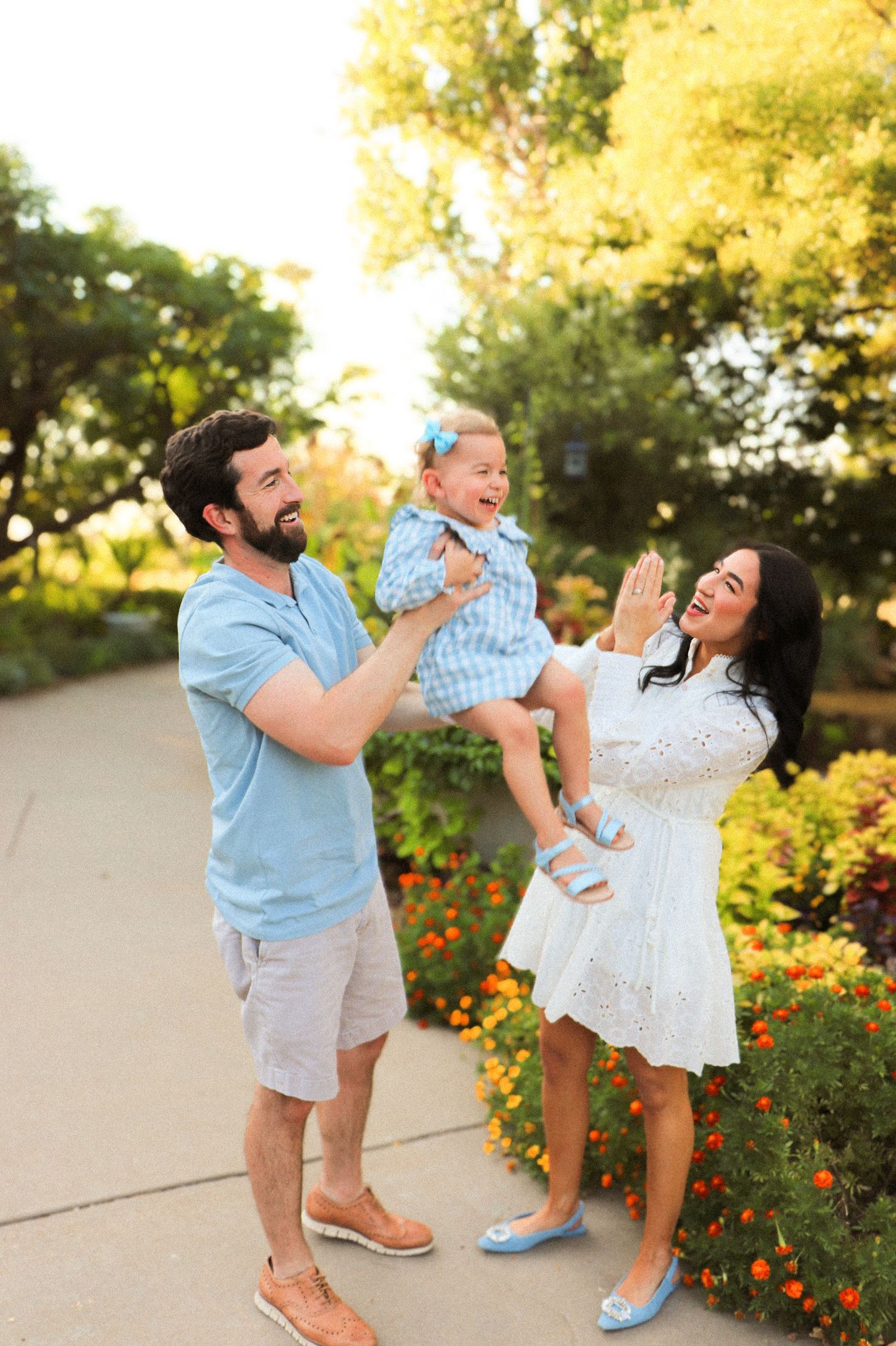 Family shares joyful moment in garden with blooming yellow flowers.