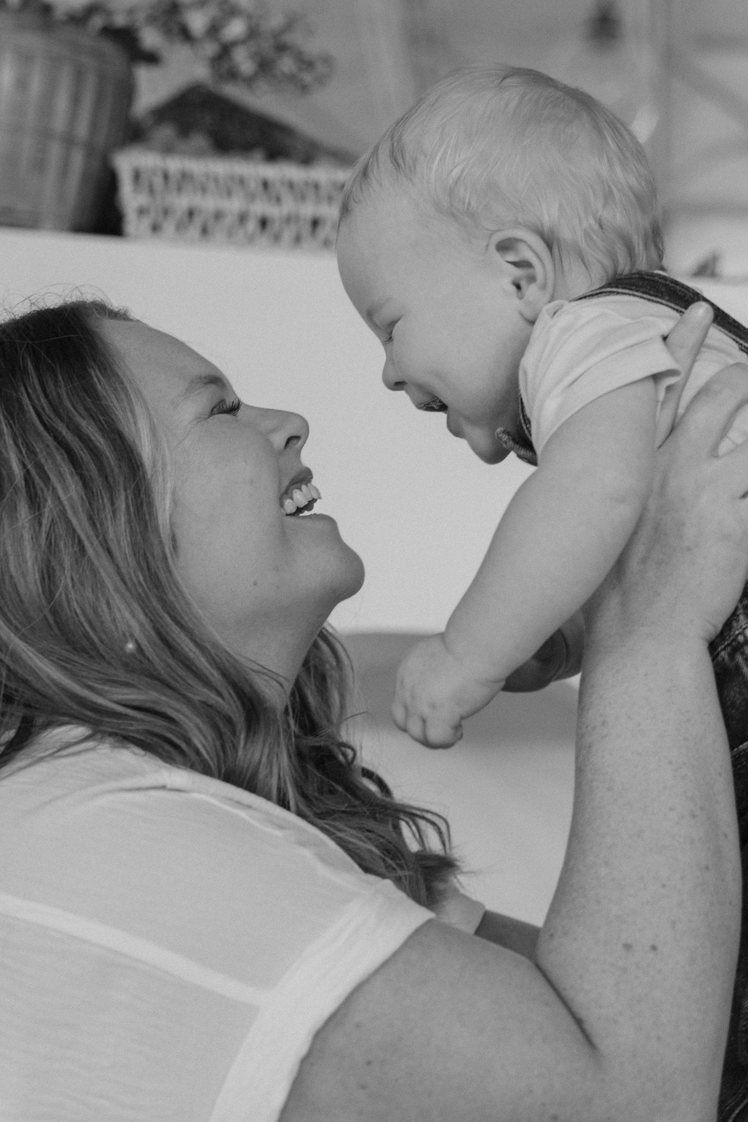 A tender black and white portrait capturing a joyful moment between a parent and baby.