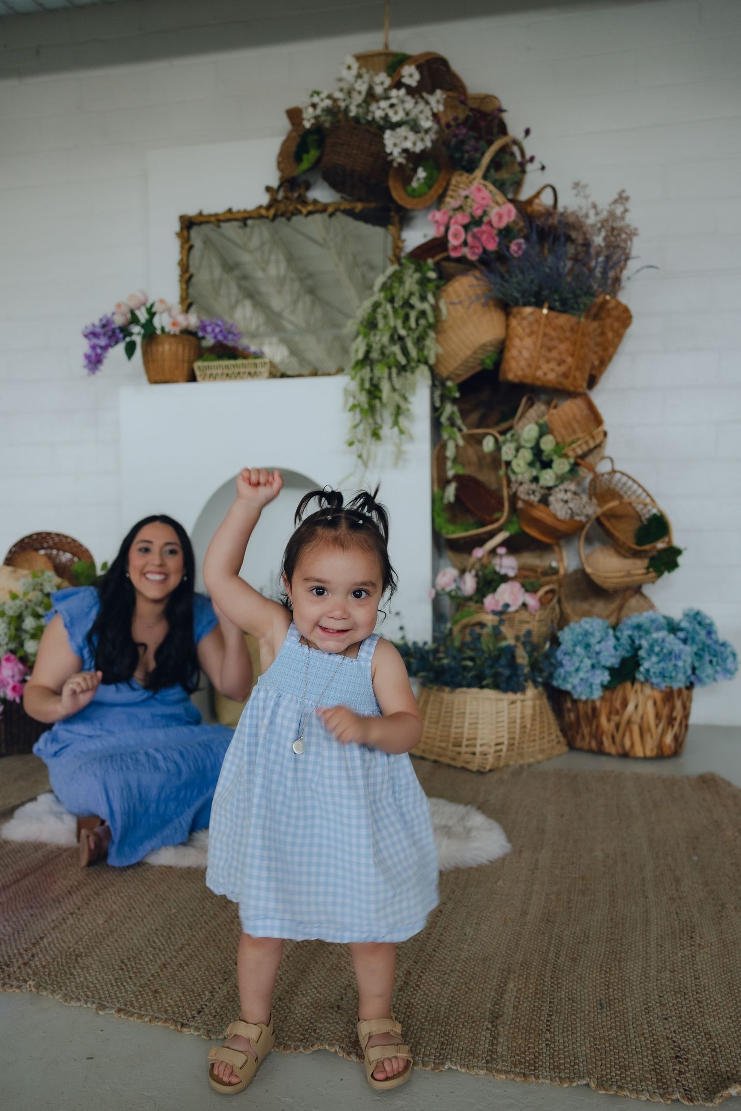 A whimsical indoor scene with decorative plants arranged around a mirror and joyful dancing on a brown rug.
