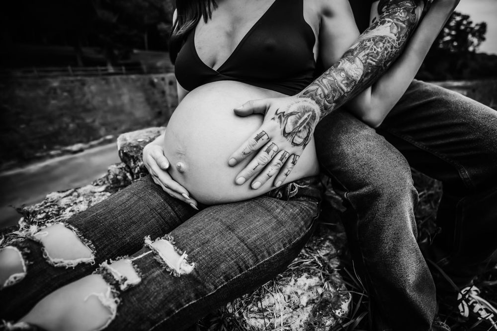 Pregnant woman with husband's hands on her belly in Dickson, TN.