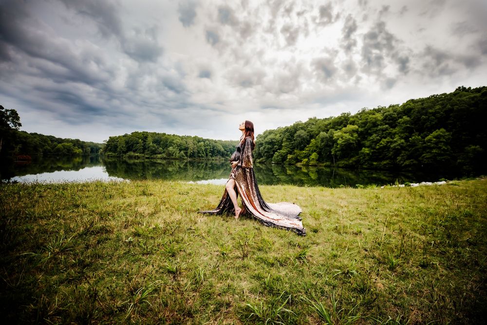 Pregnant woman at her maternity session in gown in front of lake in Dickson, TN.