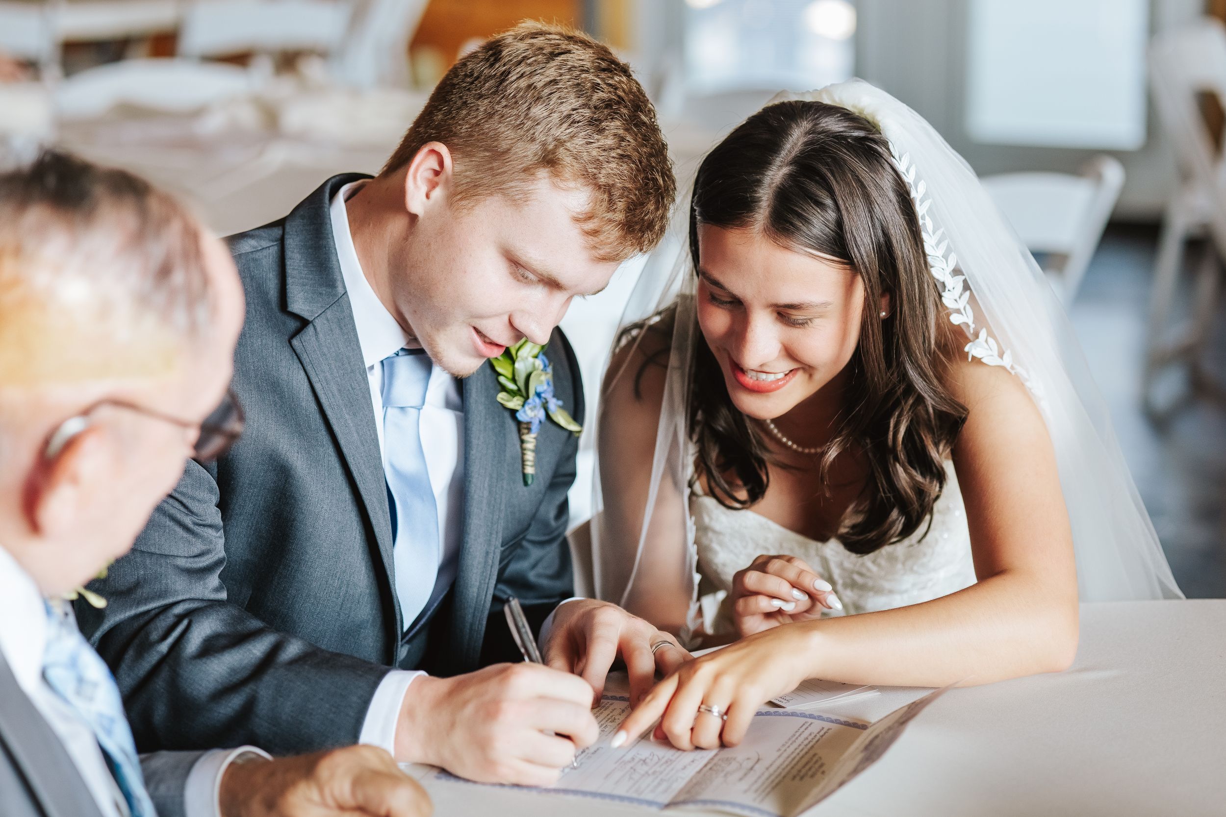 Wedding guests share laughter and conversation during indoor celebration.