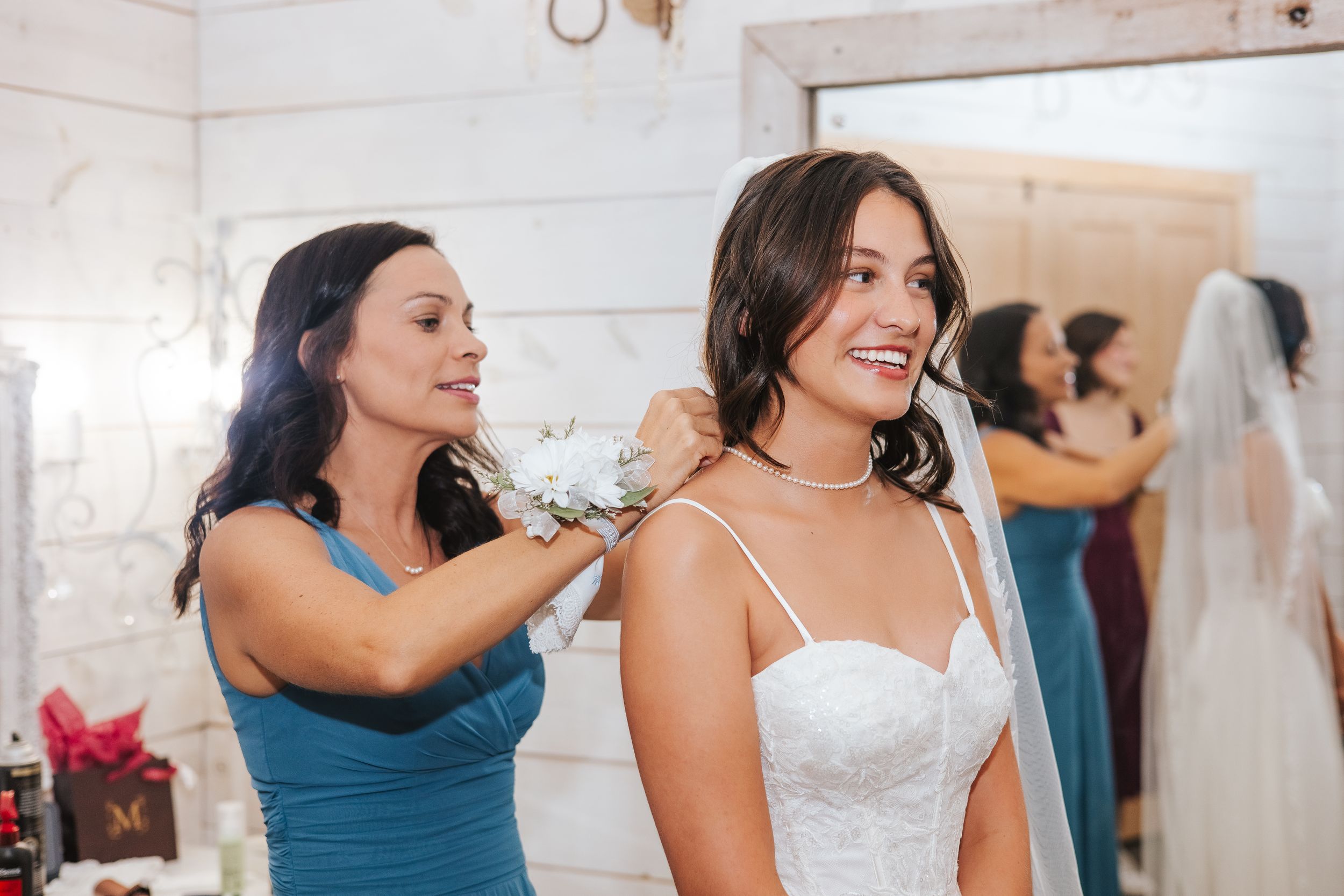 Wedding party members in blue dresses share emotional embraces during celebration.