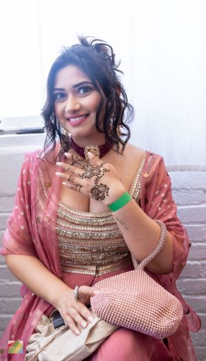Close-up of intricate traditional Indian jewelry and fashion accessories in pink and gold tones.