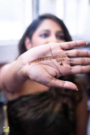 Close-up of a hand showing a henna tattoo with text design.