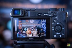 Sony camera display showing festival panel discussion through viewfinder.