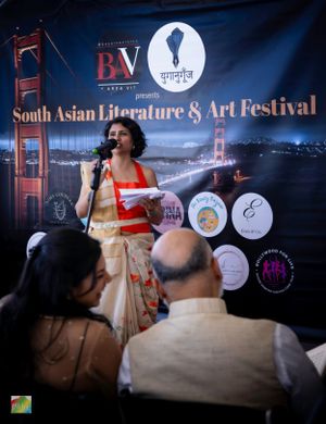 Literature festival performer speaking at podium with San Francisco skyline backdrop.