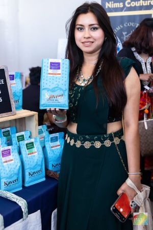 Vendor displays packaged tea products at merchandise booth during festival.