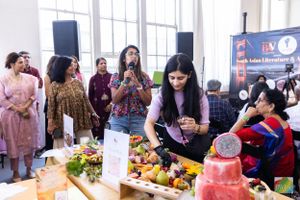 Event attendees gather around a table with fresh fruit displays and refreshments.