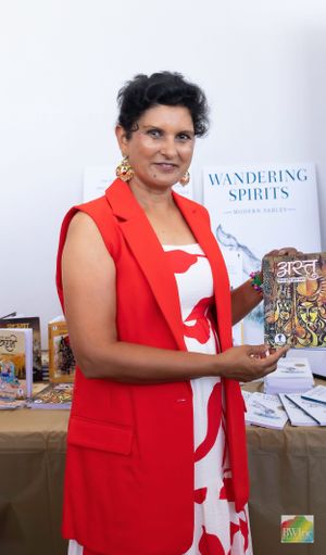 A person in a red and white dress holding books at a promotional event display.