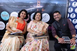 Three people seated at an event with the Golden Gate Bridge backdrop display banner.