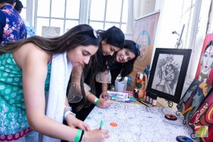 Artists working together on a coloring project at a creative workshop event.
