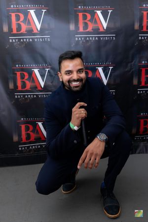 Man in navy blazer posing against BAV event backdrop.