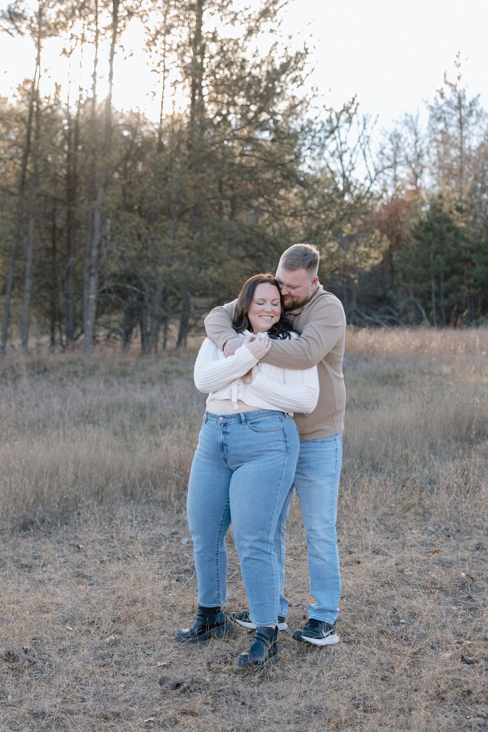Candid moments of couple in coordinated outfits enjoying autumn afternoon in field.
