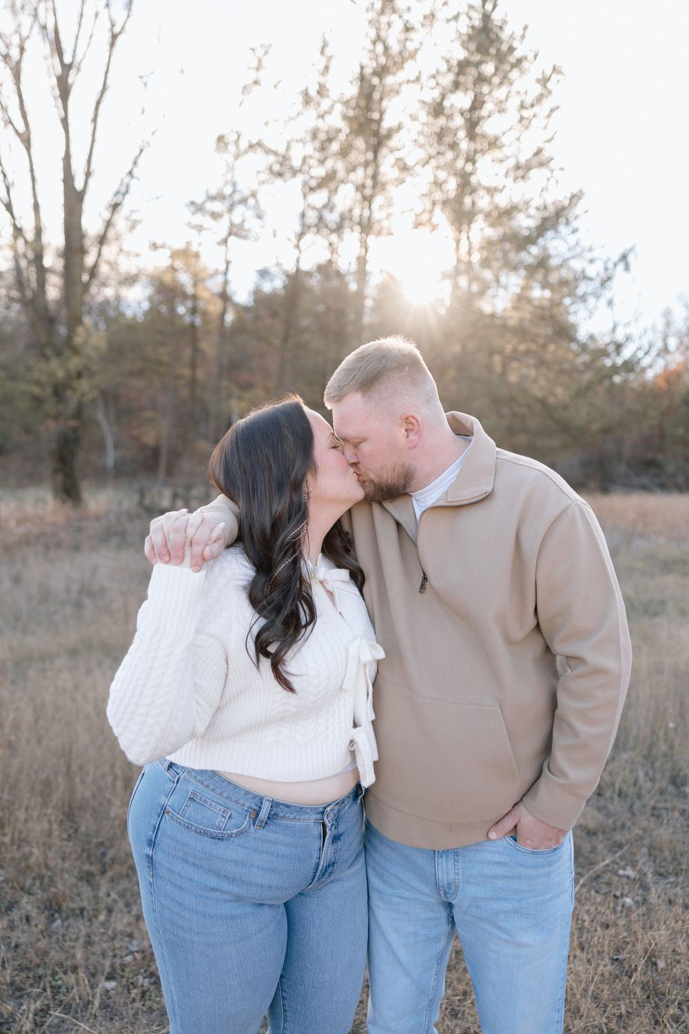 Romantic autumn photoshoot with couple in casual wear embracing in golden field.
