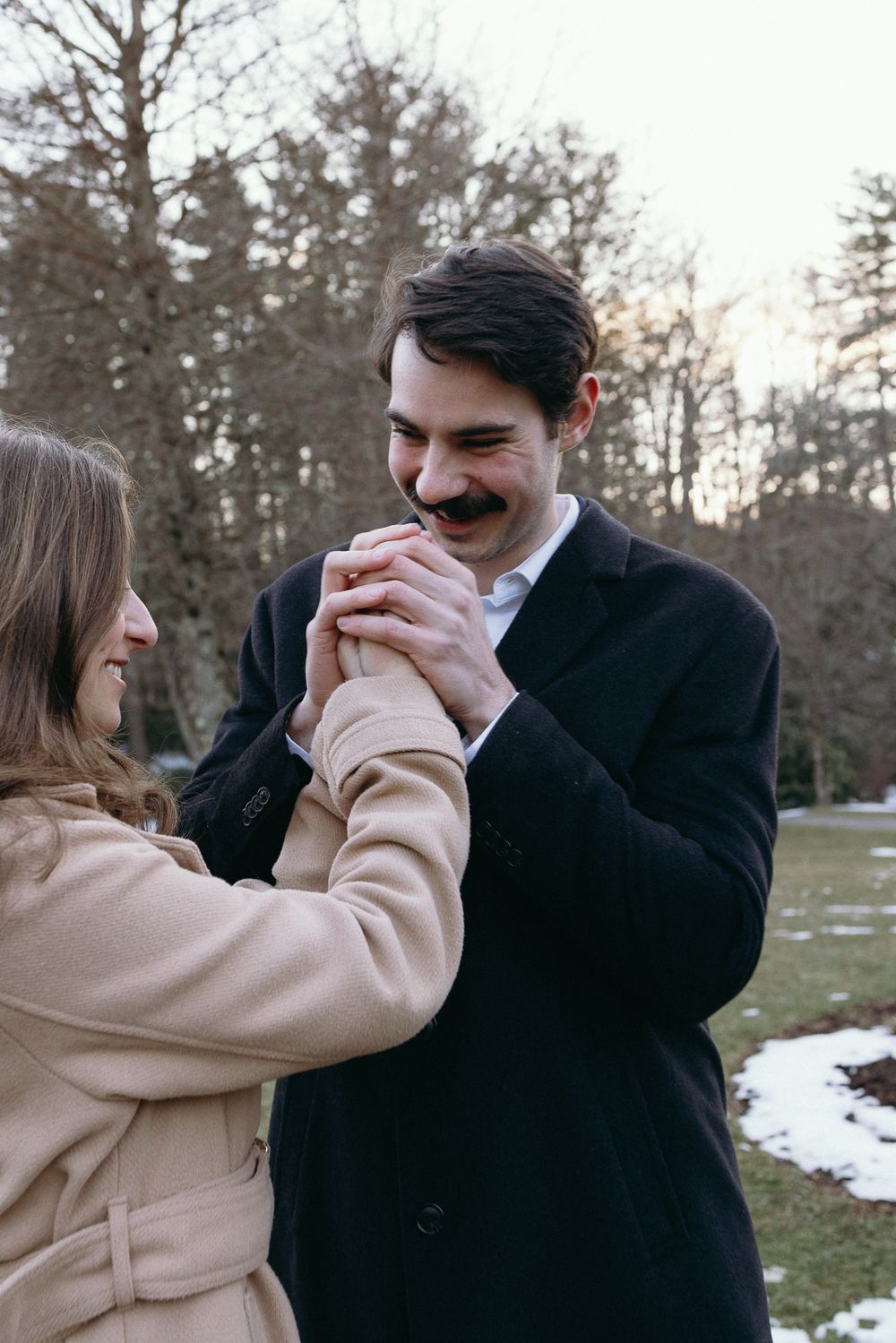 A couple shares an intimate moment outdoors during winter near bare trees. Castle  Ladyhawke Wedding Photographer