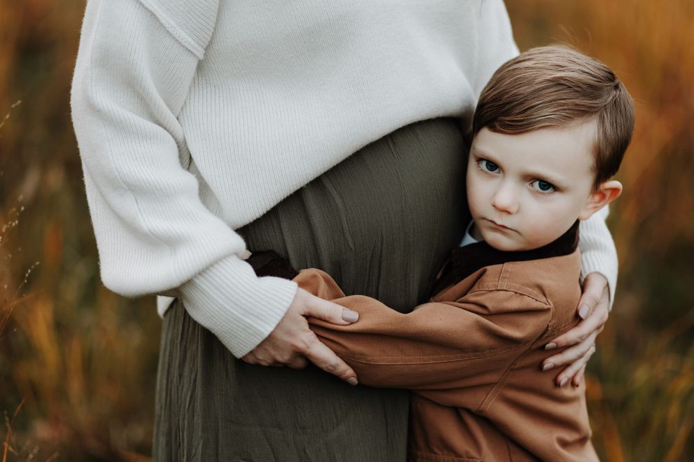 Fall maternity pictures taken with mother and son in Burton, Michigan
