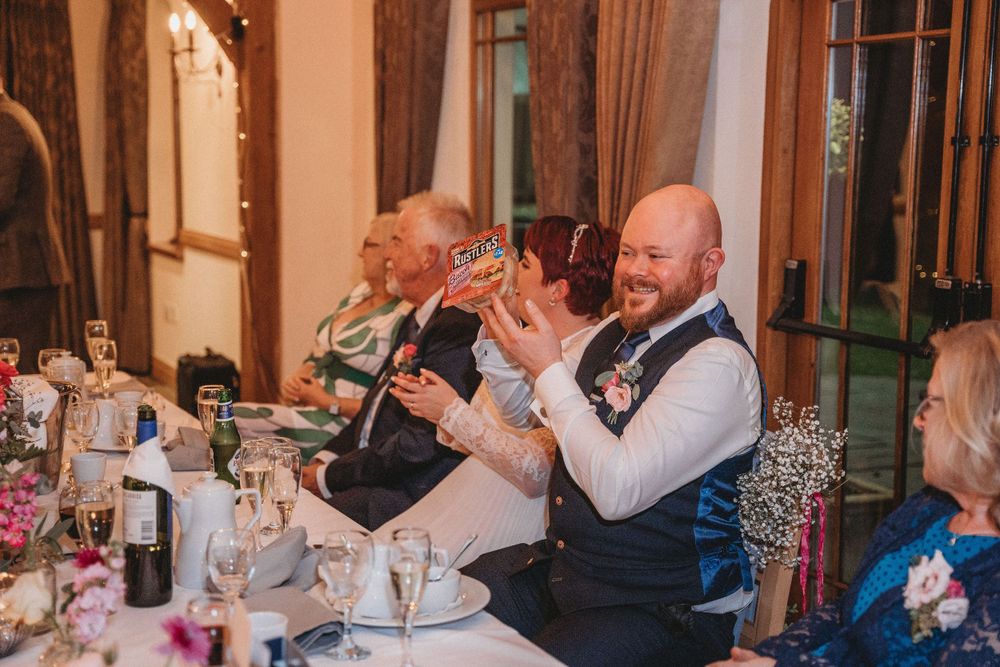 Wedding reception dinner setup with pink floral centerpieces and elegant table settings.