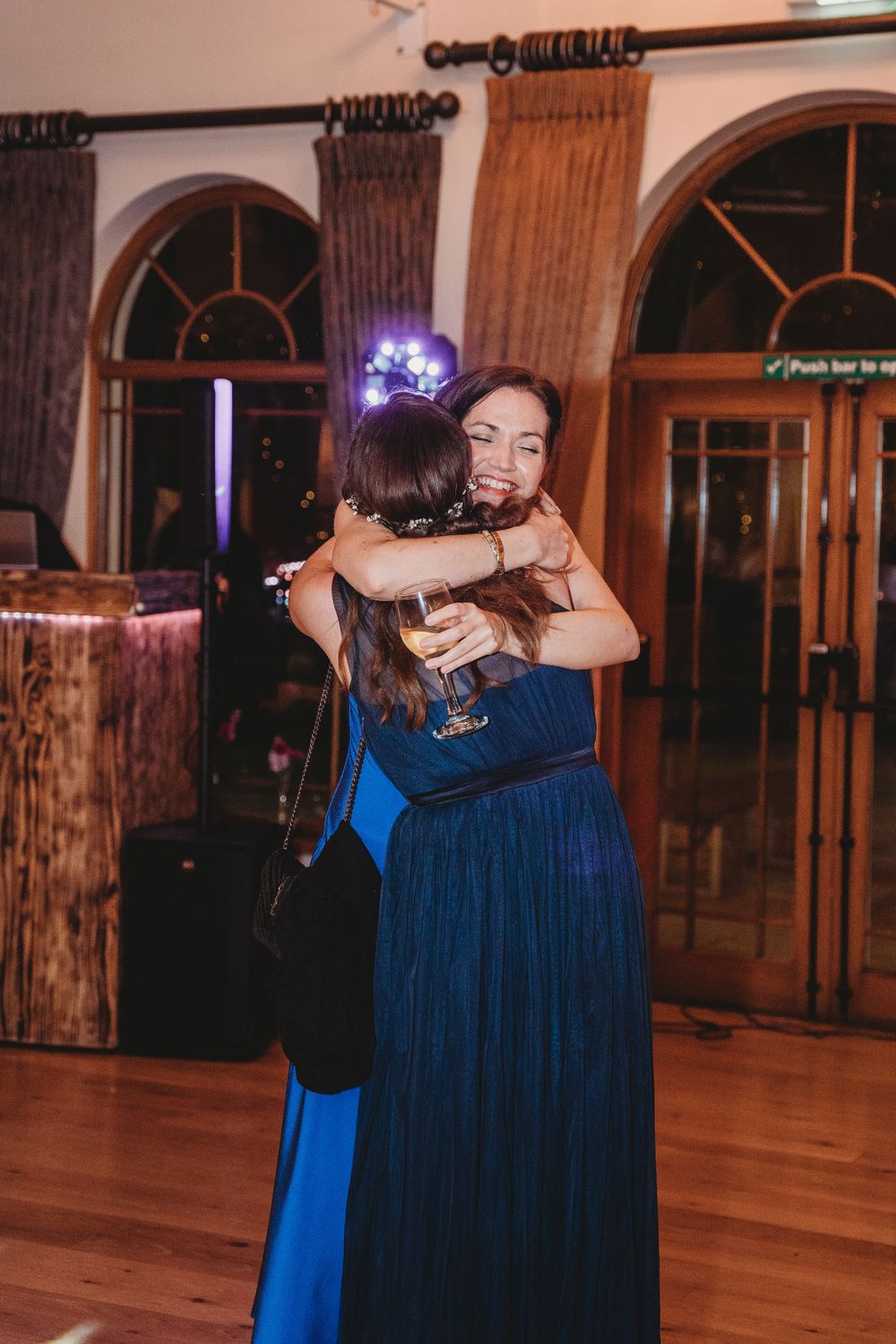 Wedding guests embracing during an emotional moment at the reception.
