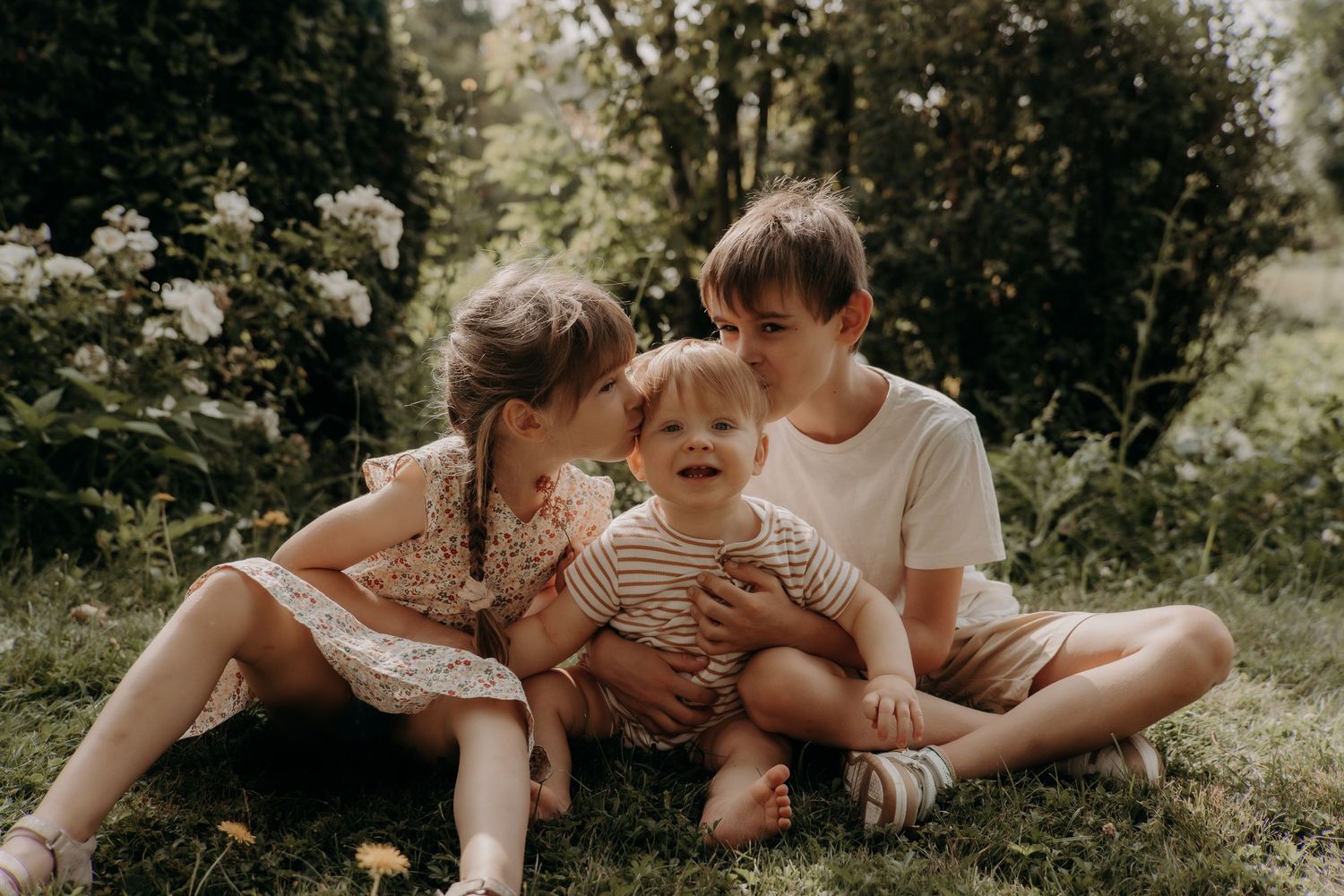 Candid family moments captured while lounging on grass during outdoor photography session.