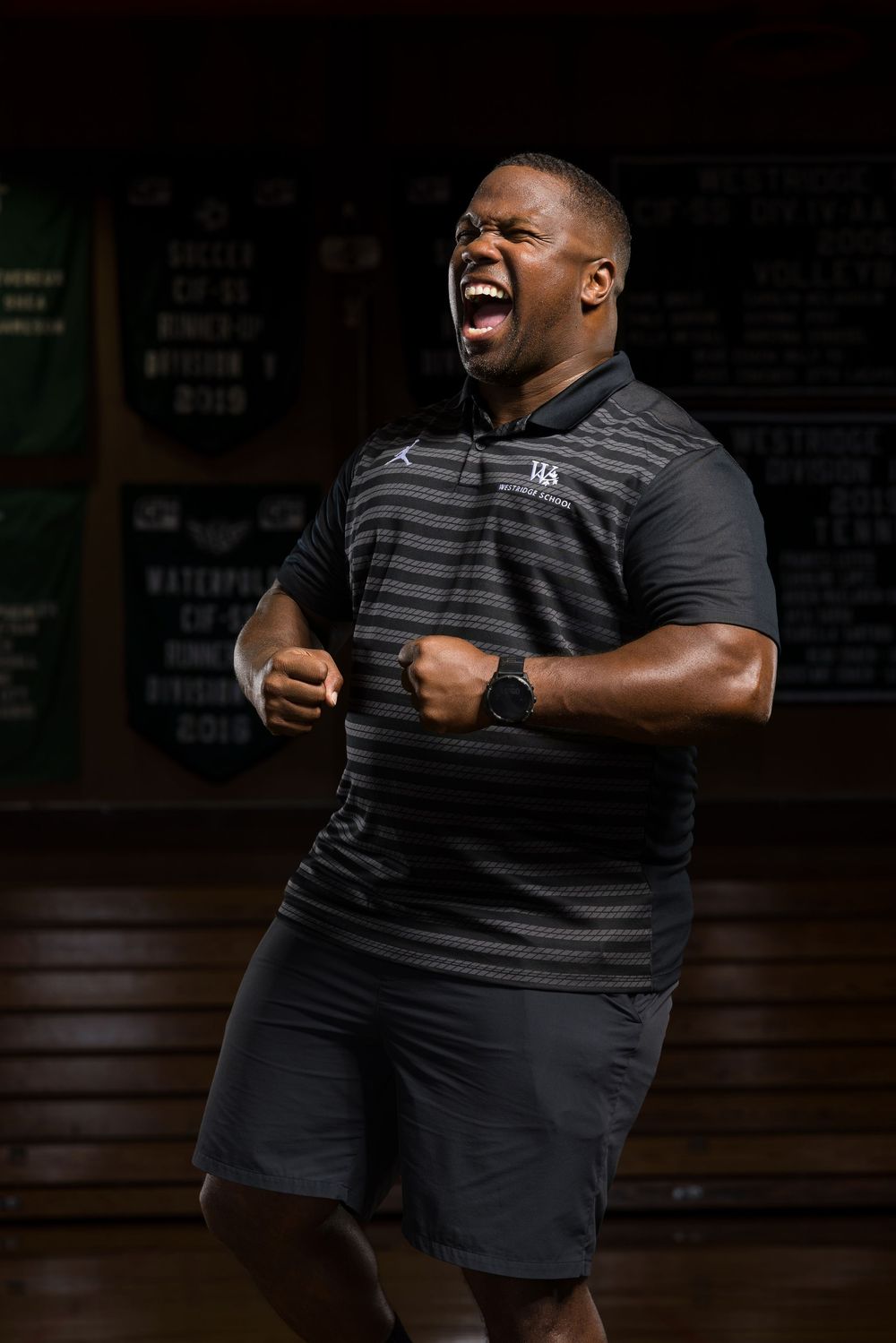 A person in a black striped shirt expressing joy and excitement through animated gestures and expressions.