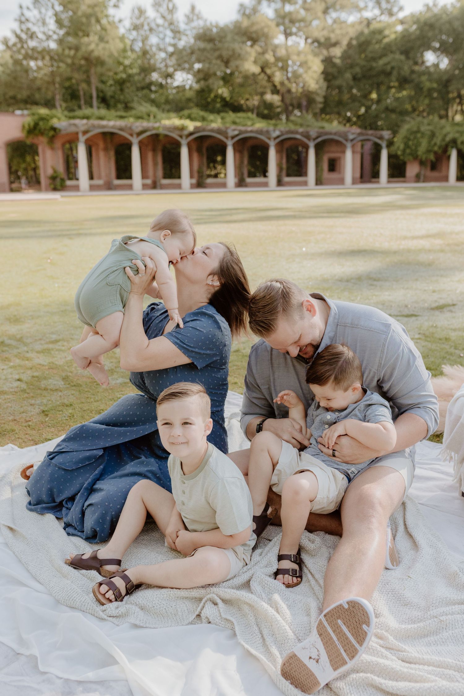 Sweet candid family moments captured during outdoor photo session near arched building.