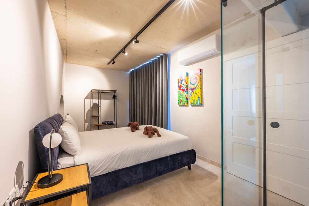 Contemporary white living space with track lighting and modern furnishings.