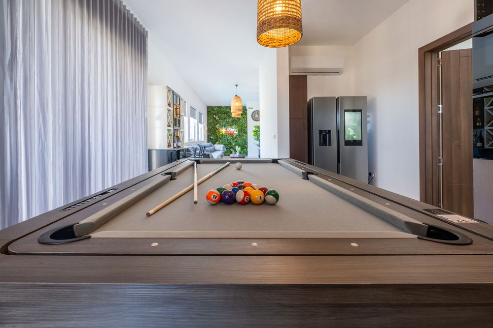 Modern interior hallway with wood flooring, white walls, and pendant lighting fixtures.