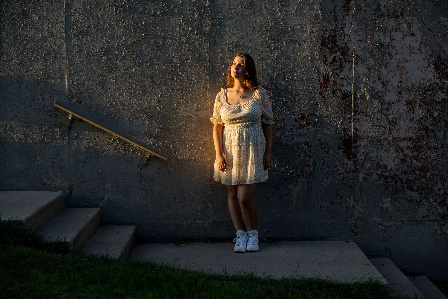Dramatic sunset lighting creates silhouettes against textured wall background.