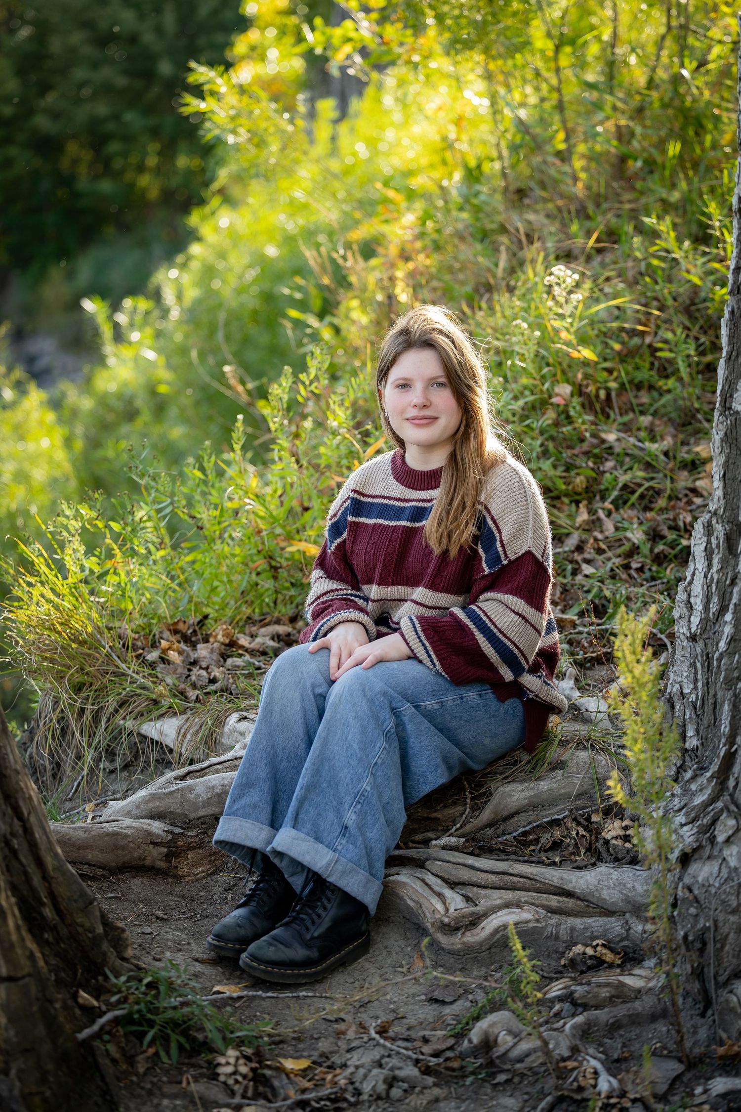 Natural outdoor portrait session among fallen logs and autumn foliage.