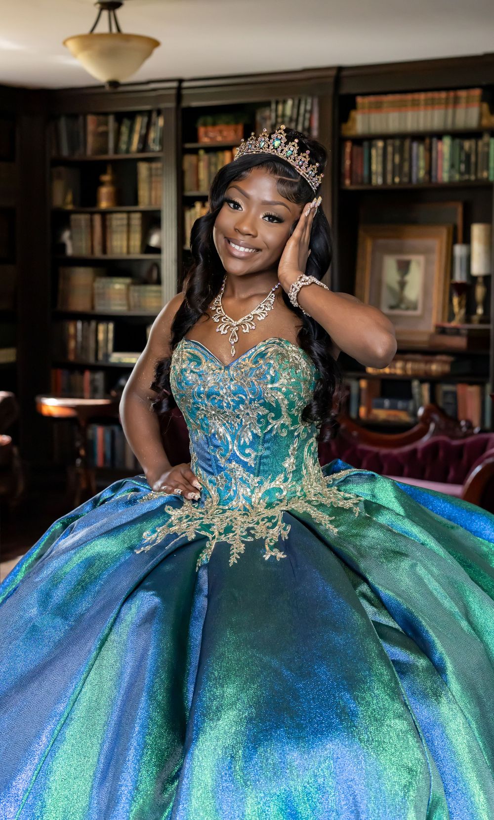 Sparkling teal and blue ball gown with crystal details photographed in library setting.