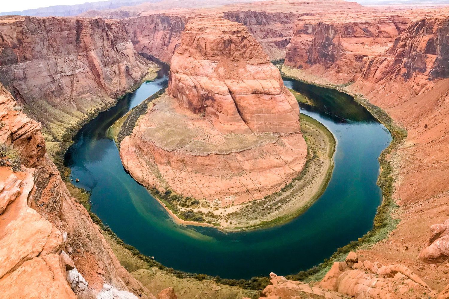 Arizona travel photography of the Horseshoe Bend canyon overlook with the Colorado River curving around towering orange sandstone cliffs.