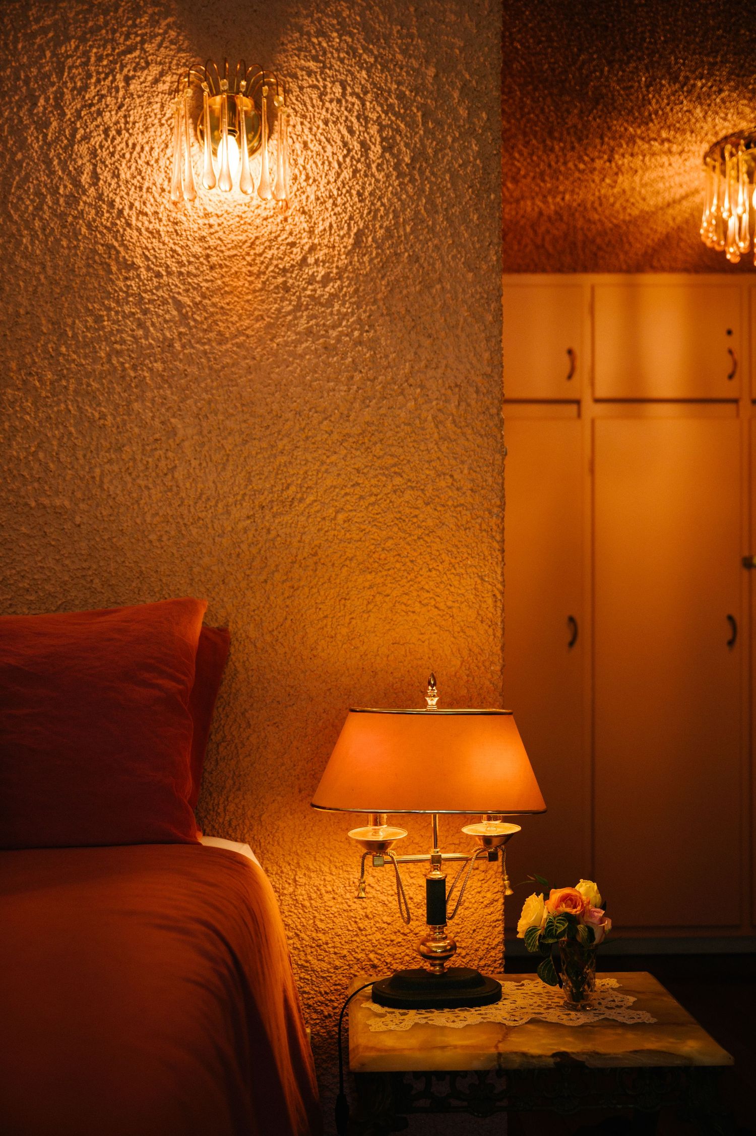 A cozy restaurant corner with warm lighting, red seating, and a table lamp creating an intimate ambiance.