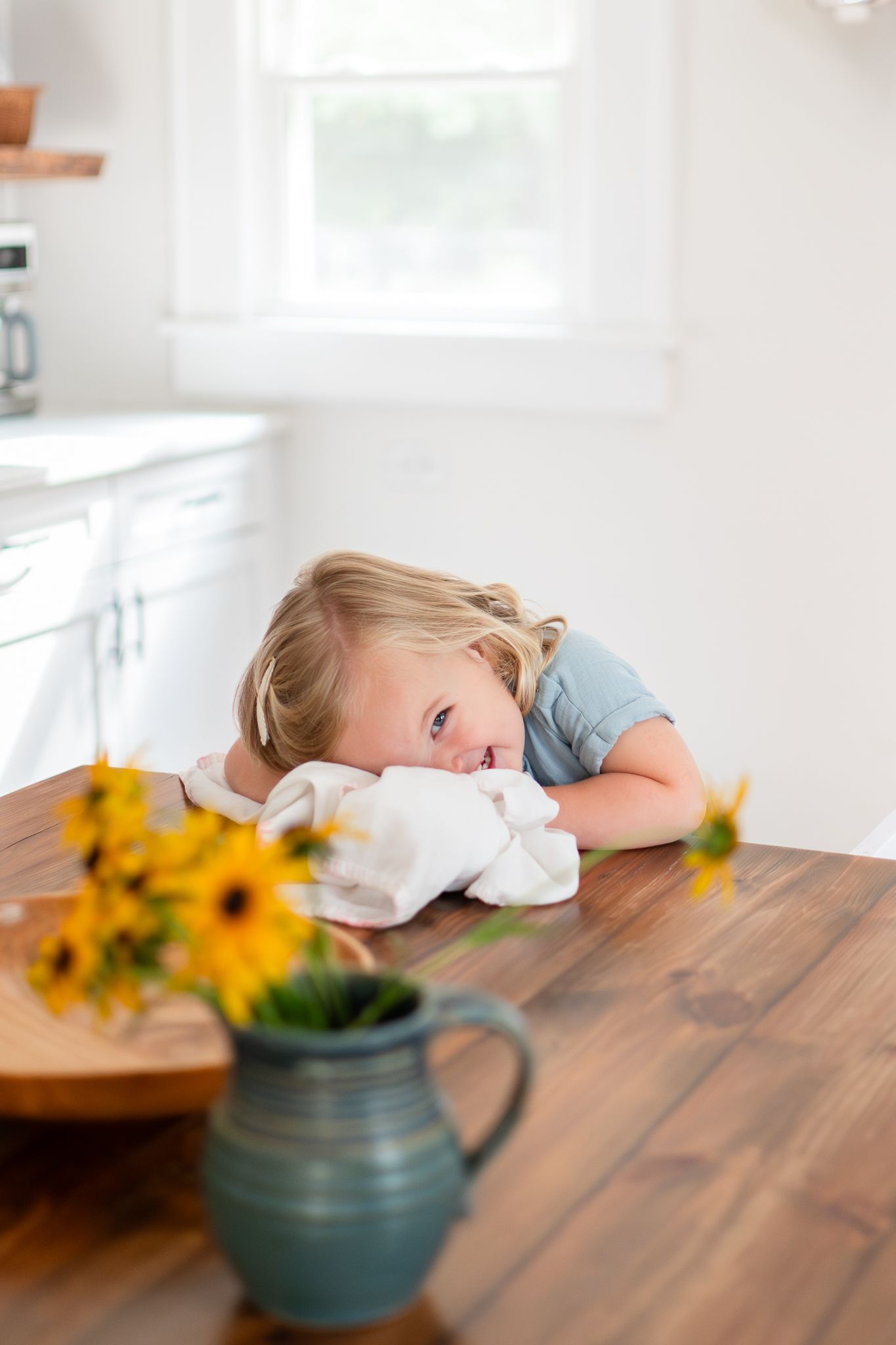 A girl snuggles her blankie in their family kitchen during Winston-Salem family photos.