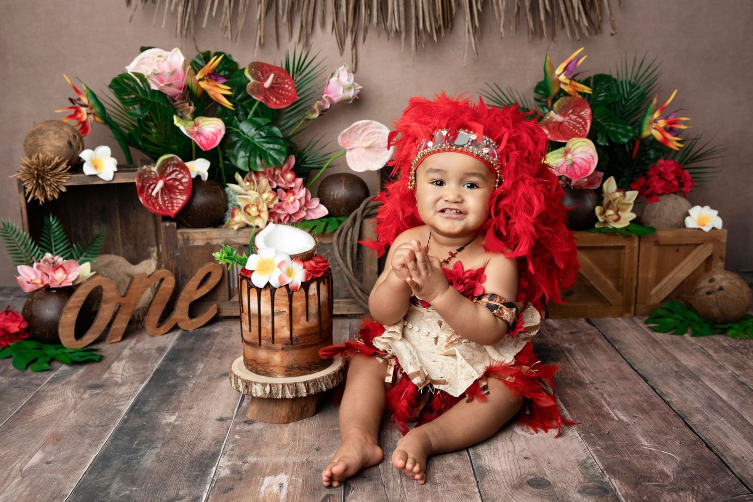 Tropical themed first birthday setup with wooden decorations and floral arrangements.